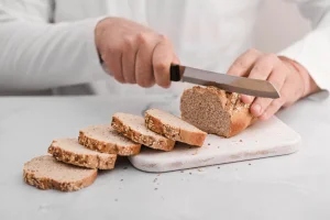 A person cutting bread into slices