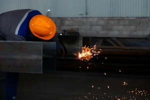 Operator using a plasma cutter to cut metal