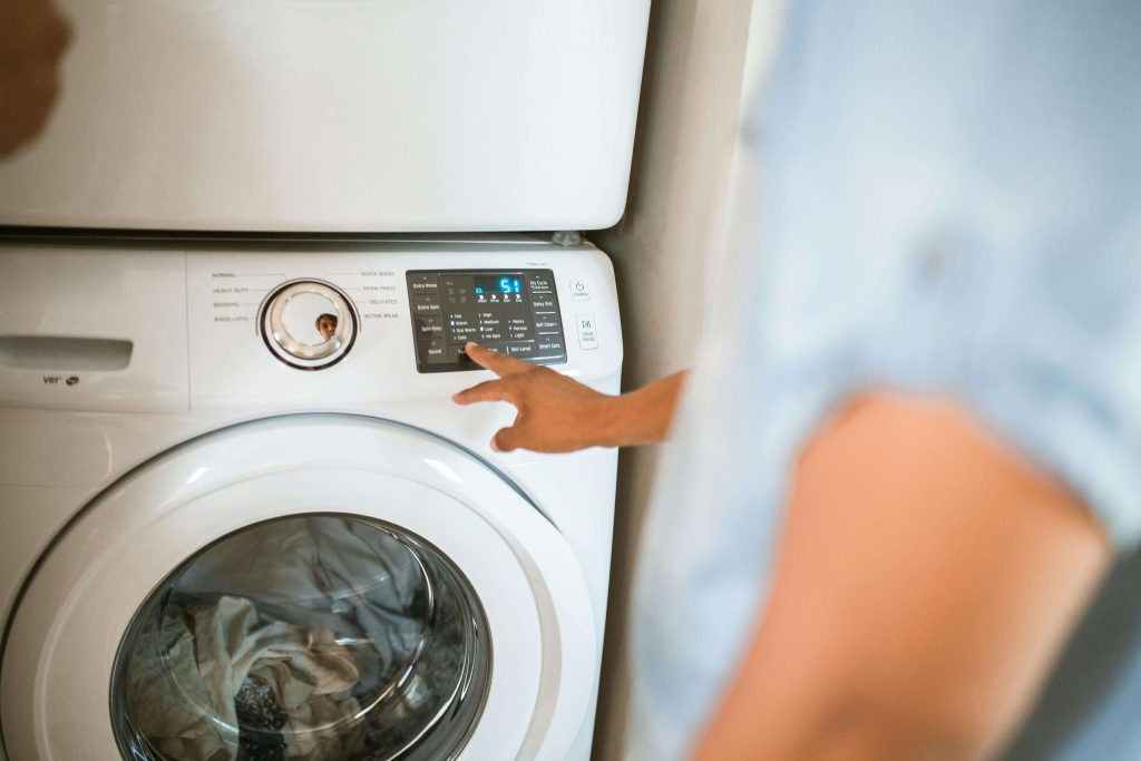 Person pressing buttons on a dryer.