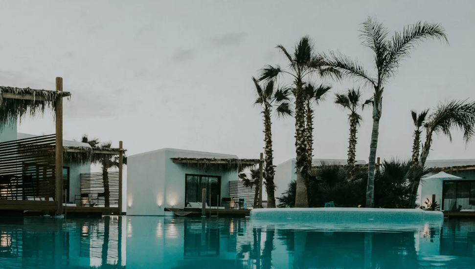 a pool surrounded by rooms and trees