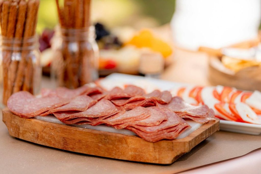 Deli meat on top of wooden tray.